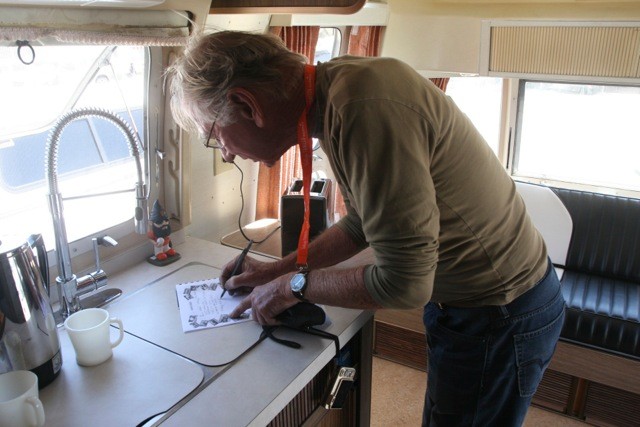 Marcus finding out his trailer's history and writing notes into the vintage trailer booklet...